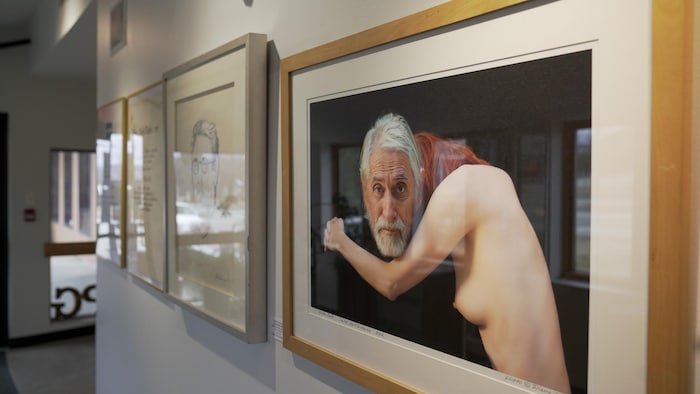 Une photo d'un homme âgée et d'une femme, nue, de côté et penchée sur son épaule. 